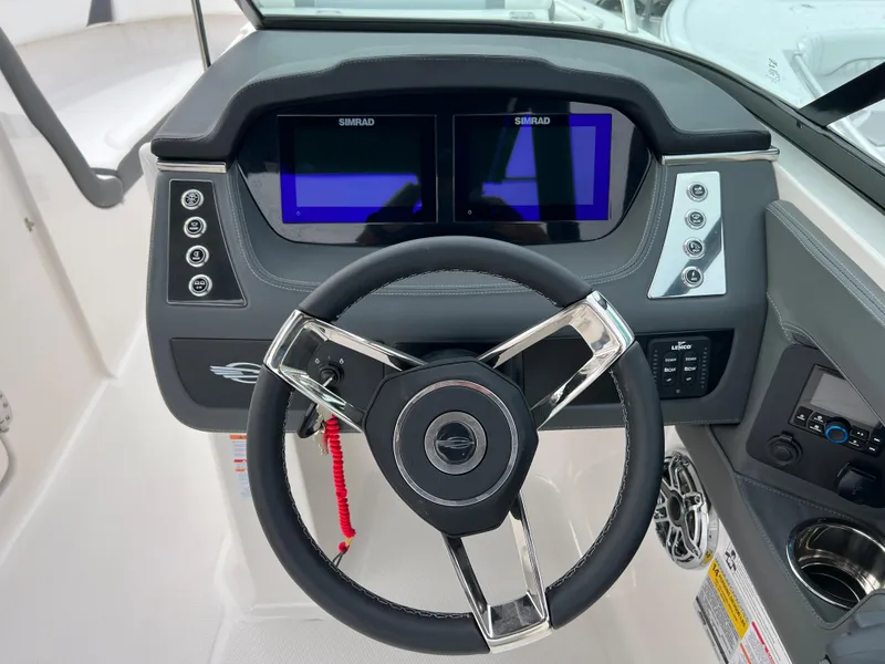 Slide: The Image of 2023 Chaparral 250 OSX boat dashboard with dual Simrad displays and modern steering wheel. - 12