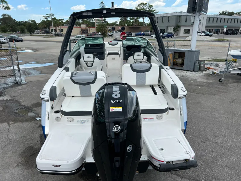 Slide: The Image of 2023 Chaparral 250 OSX boat with V8 engine, rear view in a parking lot. - 3