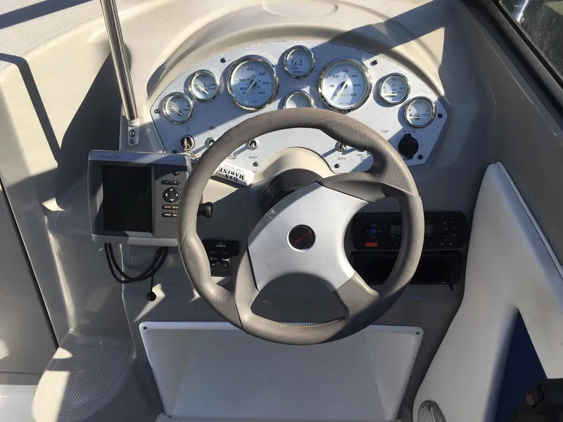 Slide: The Image of 2011 Bayliner Discovery 192 boat dashboard with steering wheel and instrument panel. - 3