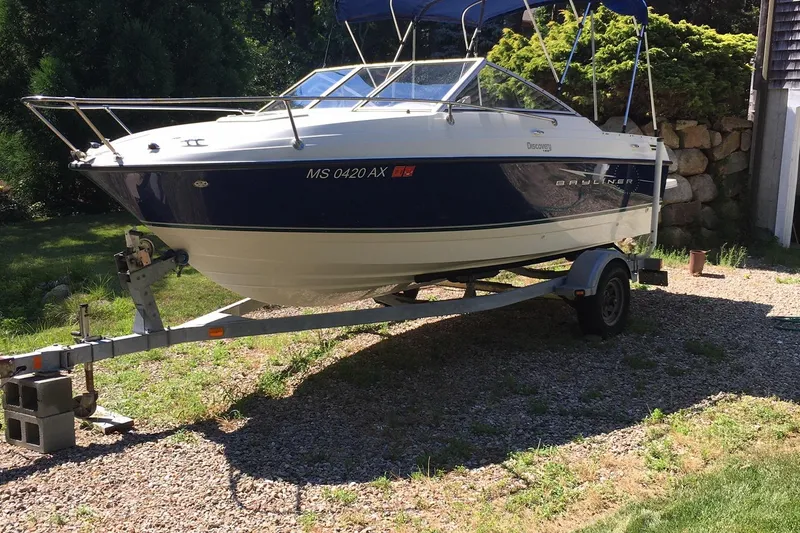 Slide: The Image of 2011 Bayliner Discovery 192 boat on a trailer in a sunny yard. - 7