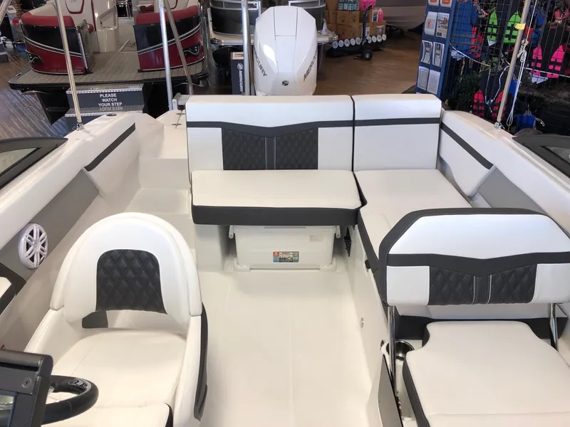 Slide: The Image of 2024 Monterey M-205 boat interior with white and black seating, helm chair, and storage. - 13