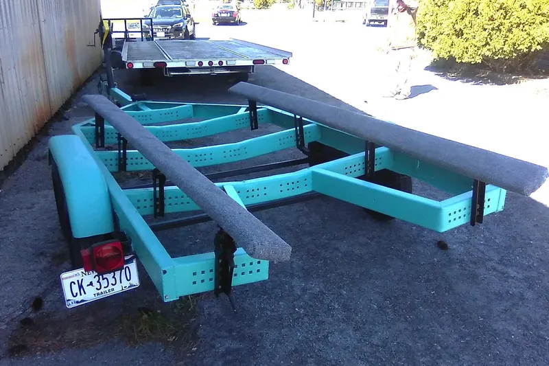 Slide: The Image of 1963 Coronado 21 by Century boat trailer, turquoise frame, parked on gravel. - 16