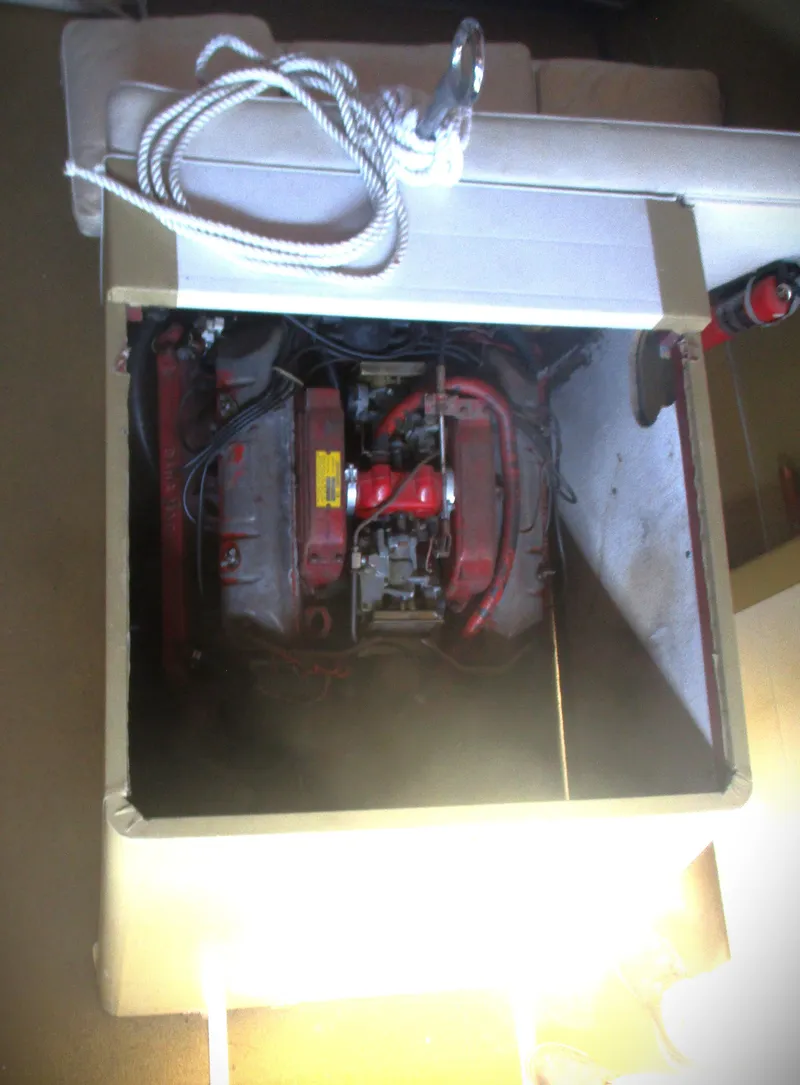 Slide: The Image of 1963 Coronado 21 by Century boat engine compartment with visible engine and coiled rope. - 7