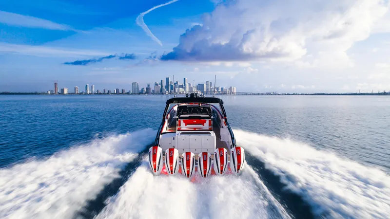 Slide: The Image of 2025 Cigarette 52 Thunder speedboat cruising towards city skyline. - 14