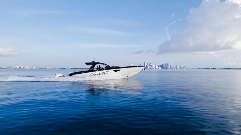 Slide: The Image of Cigarette 52 Thunder 2025 speedboat cruising on calm blue waters with city skyline in background. - 23