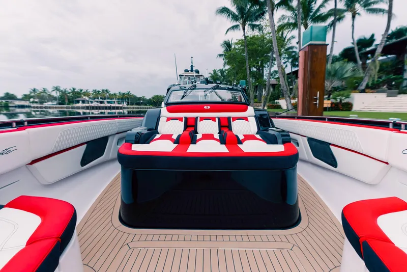 Slide: The Image of 2025 Cigarette 52 Thunder boat with luxurious red and white seating, docked near palm trees. - 28