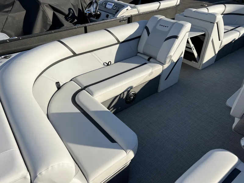 Slide: The Image of 2024 Crest Classic LX 220 pontoon boat with luxurious white seating. - 14