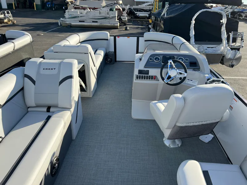 Slide: The Image of 2024 Crest Classic LX 220 pontoon boat interior with plush seating and modern helm. - 15