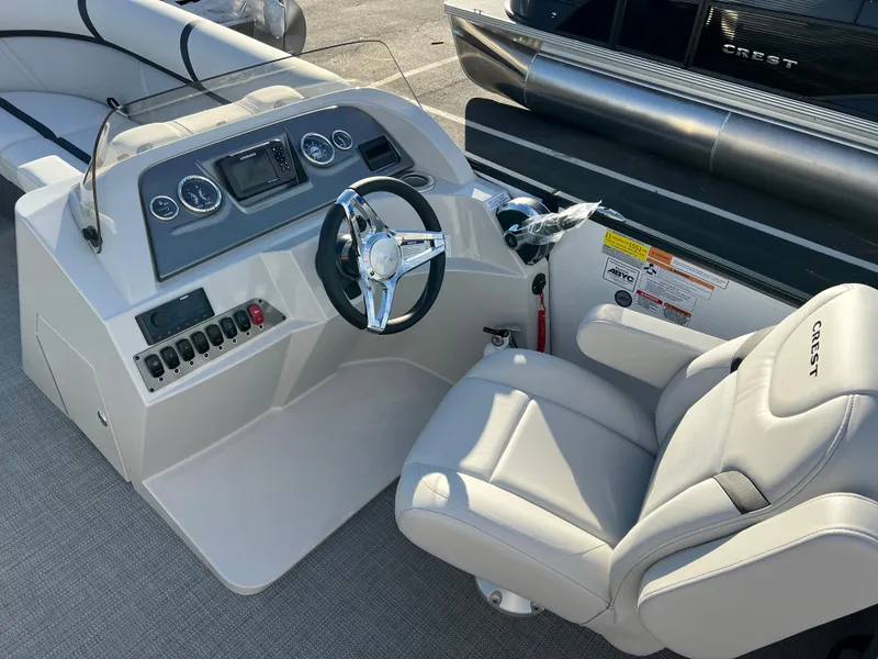 Slide: The Image of 2024 Crest Classic LX 220 boat dashboard and captain's chair, featuring modern controls and comfortable seating. - 16