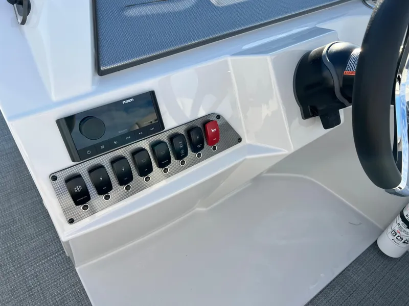 Slide: The Image of Control panel of 2024 Crest Classic LX 220 pontoon boat with switches and steering wheel. - 18