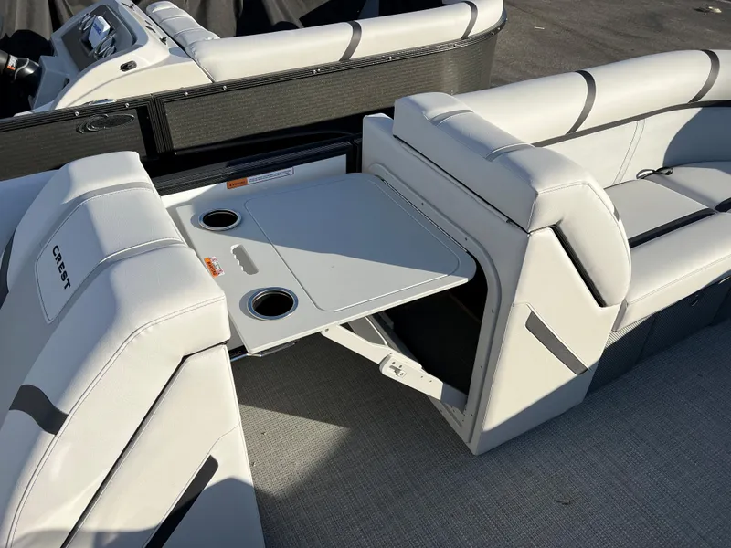 Slide: The Image of 2024 Crest Classic LX 220 boat interior with fold-out table and cup holders. - 19
