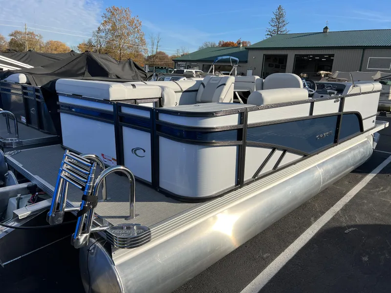 Slide: The Image of 2024 Crest Classic LX 220 pontoon boat in a parking lot. - 2