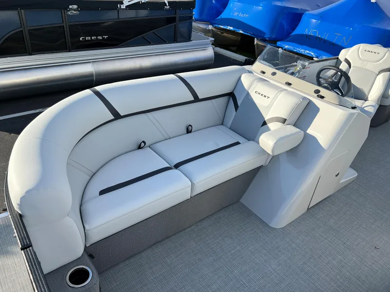 Slide: The Image of 2024 Crest Classic LX 220 pontoon boat interior with plush seating and modern helm. - 4