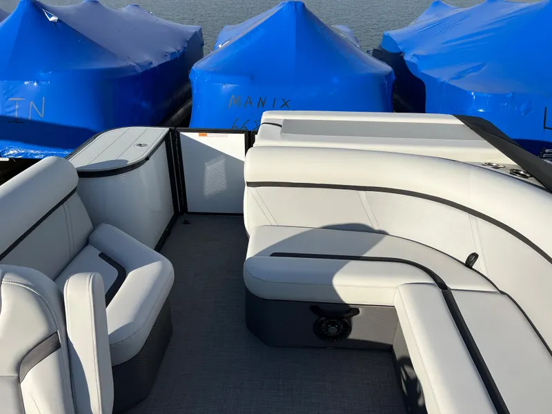 Slide: The Image of 2024 Crest Classic LX 220 boat interior with plush seating and blue covered boats in the background. - 7