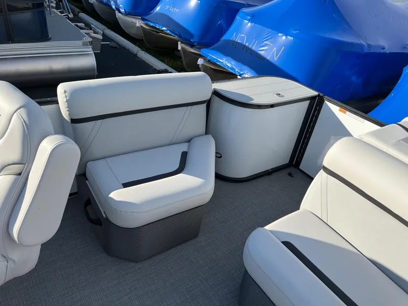 Slide: The Image of 2024 Crest Classic LX 220 pontoon boat interior with plush seating and storage. - 9