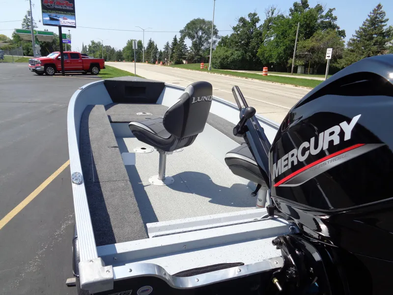 Slide: The Image of 2024 Lund 1600 Fury Tiller boat with Mercury engine, parked outdoors. - 4