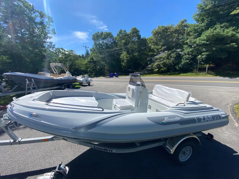 Slide: The Image of 2024 Zar Formenti 43 boat displayed at a dealership with other boats. - 9