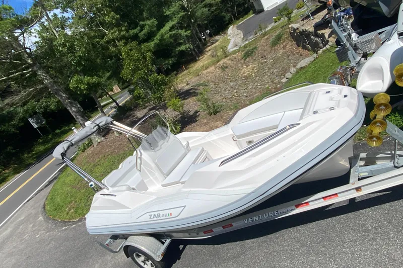 The Image of 2024 Zar Formenti 49 SL boat on a Venture trailer, parked on a road. - 0