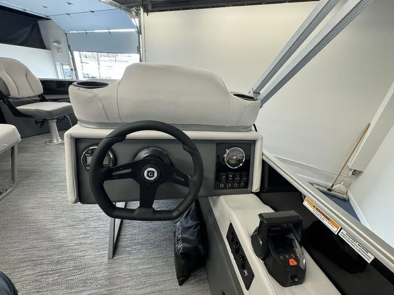 Slide: The Image of 2024 Godfrey MG 1476 F boat interior, featuring steering wheel and control panel. - 10