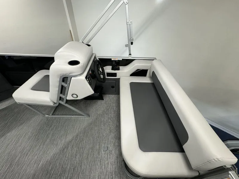 Slide: The Image of 2024 Godfrey MG 1476 F boat interior with gray and white seating and steering console. - 4