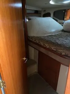 Slide: The Image of 2003 Cruisers Yachts 3772 Express cabin interior with bed and wooden door. - 11