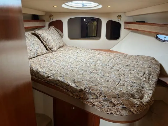 Slide: The Image of 2003 Cruisers Yachts 3772 Express cabin with a cozy bed and porthole windows. - 13