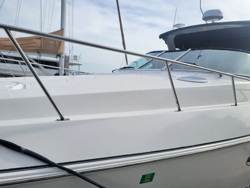 Slide: The Image of 2003 Cruisers Yachts 3772 Express docked, showcasing sleek design and stainless steel railings. - 2