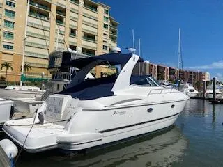 Slide: The Image of 2003 Cruisers Yachts 3772 Express docked in a marina with buildings in the background. - 4