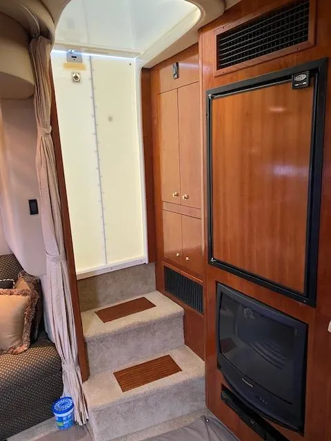Slide: The Image of Interior of 2003 Cruisers Yachts 3772 Express with wooden cabinetry and carpeted steps. - 6