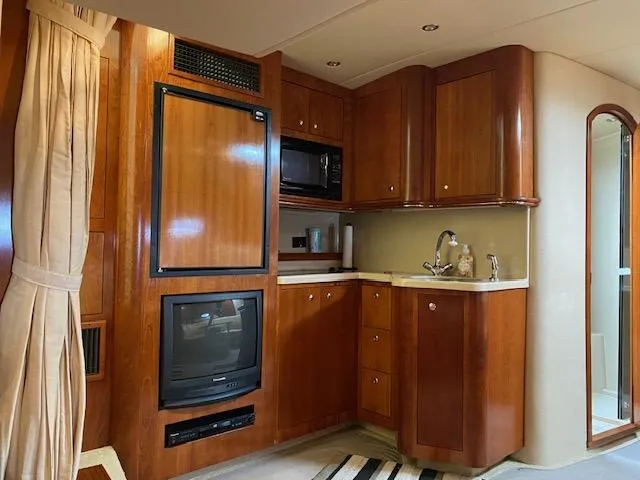Slide: The Image of 2003 Cruisers Yachts 3772 Express interior with kitchenette and entertainment center. - 7
