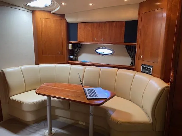 Slide: The Image of 2003 Cruisers Yachts 3772 Express interior with leather seating and wooden table. - 8