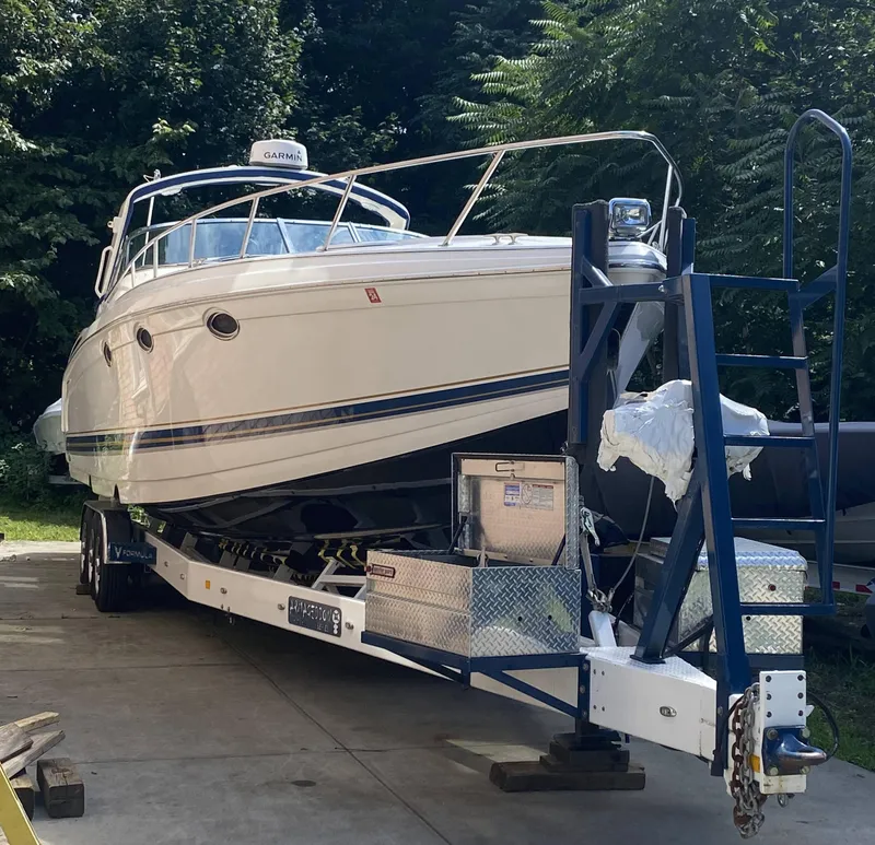 The Image of 2000 Formula 400 SS boat on a trailer, parked outdoors. - 1