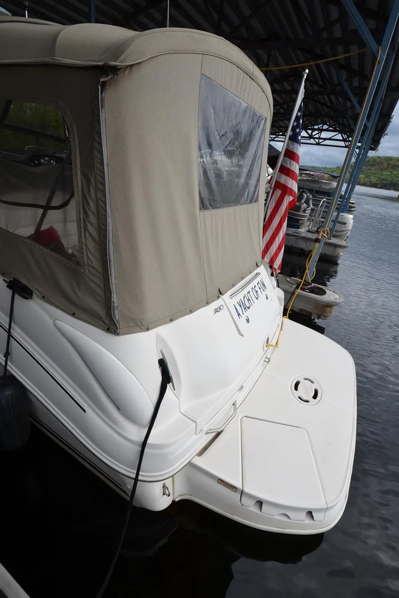 Slide: The Image of 2003 Sea Ray 280 DA docked under a covered marina with an American flag. - 3