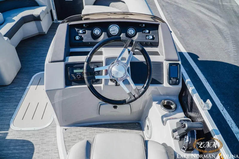 Slide: The Image of 2023 Bennington 23LSR boat dashboard with steering wheel and control panel. - 11