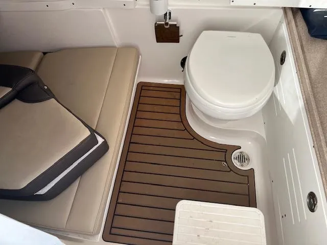 Slide: The Image of 2020 Tidewater 320 CC Adventure boat interior with toilet and seating area. - 23