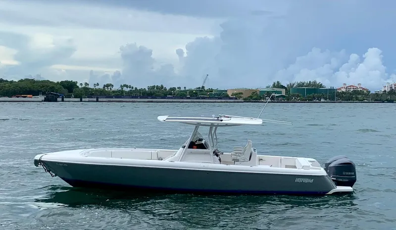 Slide: The Image of 2012 Intrepid 327 Center Console boat on water with coastal background. - 1