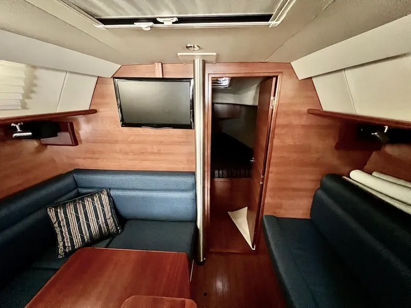 Slide: The Image of 2014 Marlow-Hunter e33 sailboat interior with seating, table, and TV. - 13