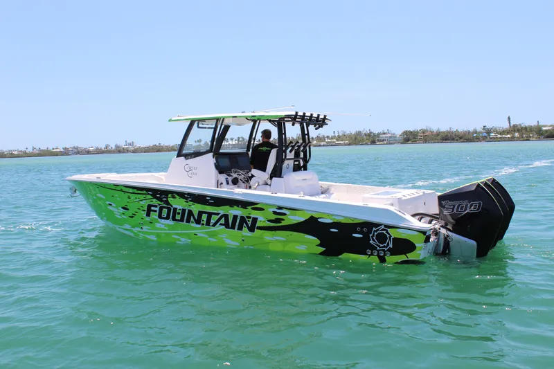 The Image of 2024 Fountain 32 NX boat with vibrant green and black design cruising on clear water. - 0