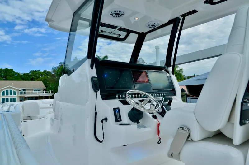 Slide: The Image of 2024 Fountain 32 NX boat cockpit with modern controls and steering wheel. - 16