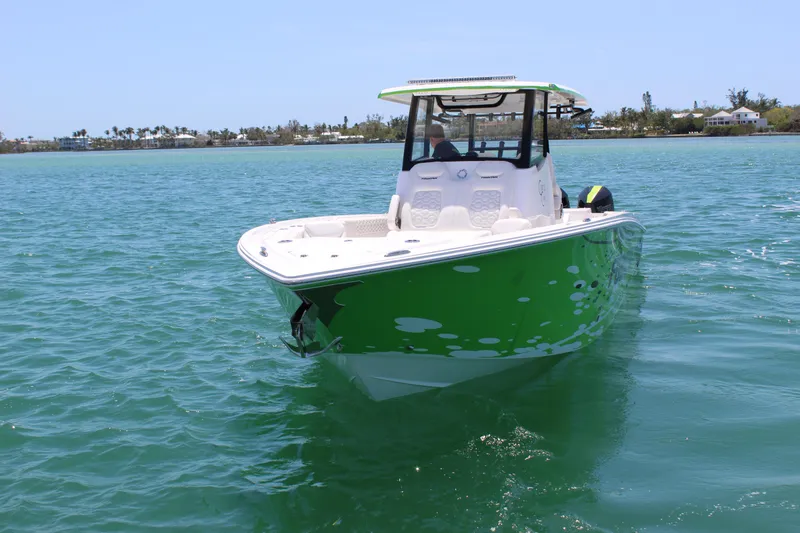 Slide: The Image of 2024 Fountain 32 NX boat in vibrant green on calm water. - 2
