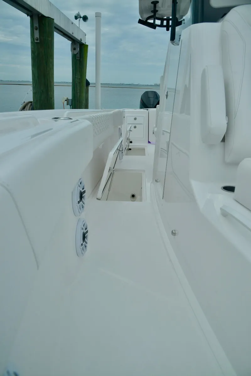 Slide: The Image of 2024 Fountain 32 NX boat interior with white seating and storage compartments. - 24