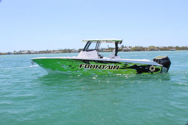 Slide: The Image of 2024 Fountain 32 NX boat with vibrant green design on calm water. - 3
