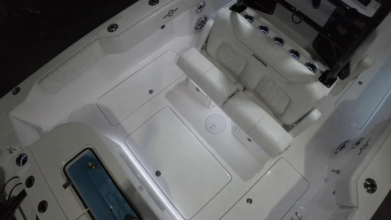 Slide: The Image of 2024 Fountain 32 NX boat interior with white seating and storage compartments. - 39