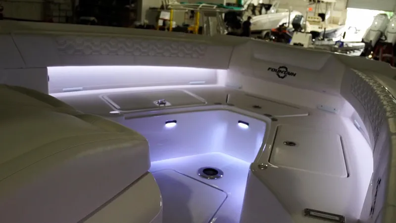 Slide: The Image of 2024 Fountain 32 NX boat interior with LED lighting in a workshop. - 51