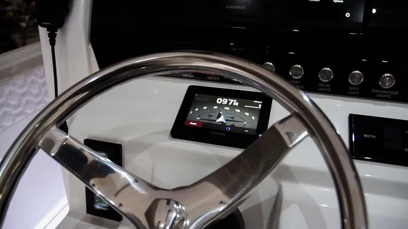 Slide: The Image of Close-up of the 2024 Fountain 32 NX boat's steering wheel and navigation display. - 54