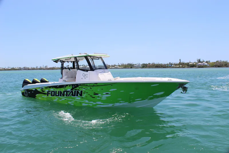 Slide: The Image of 2024 Fountain 32 NX boat in vibrant green on clear blue water. - 6
