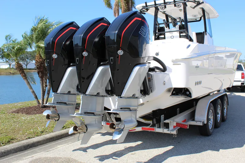 Slide: The Image of 2024 Fountain 32 NX boat with triple outboard engines on a trailer. - 8