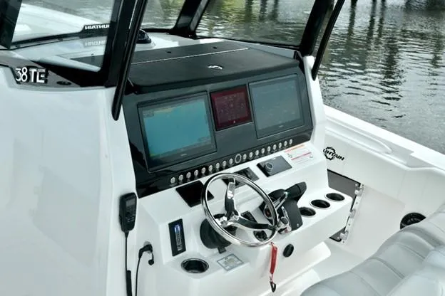 Slide: The Image of 2024 Fountain Bluewater 38 Tournament Edition boat dashboard with navigation screens and steering wheel. - 7