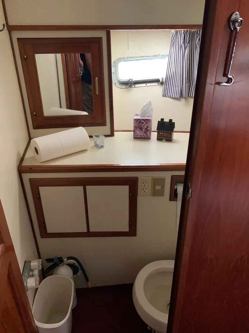 Slide: The Image of 1987 Kha Shing Vista 40 boat bathroom with mirror, sink, and toilet. - 12