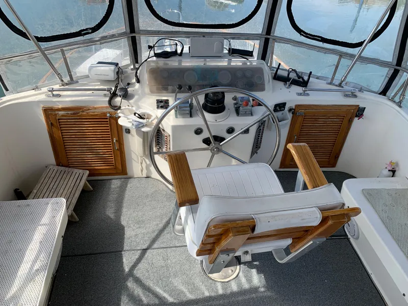 Slide: The Image of 1987 Kha Shing Vista 40 boat helm with wooden accents and captain's chair. - 3